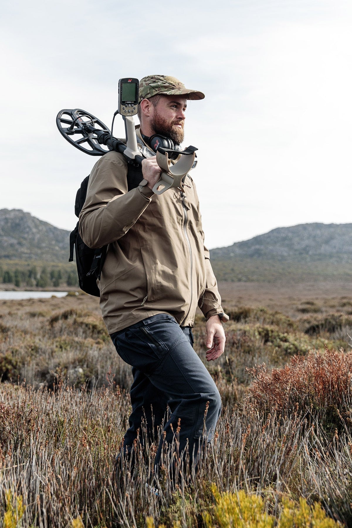 Man walking with metal detector on shoulder
