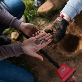 People holding treasure discovered in the ground with a Vanquish metal detector in the background