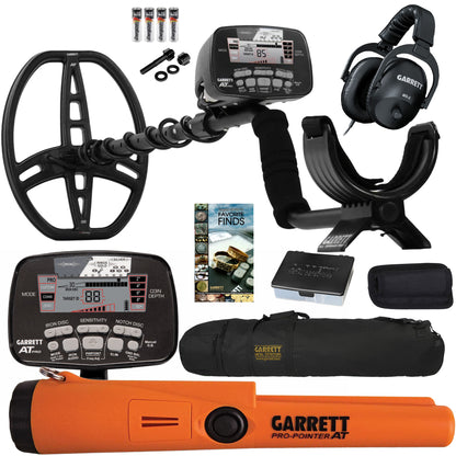 Garrett metal detector kit with a black coil, digital control unit, headphones, carrying case, orange Pro-Pointer AT, accessories, and a small book on a white background.