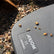 Close-up of a black Axiom 11 mono  coil on gravel, with a few small orange-brown objects scattered on the surface and the Axiom brand name visible.