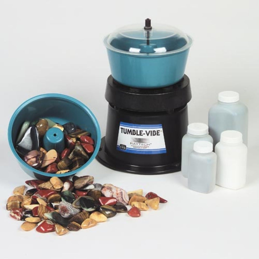 The Tumble Vibe rock polishing kit is shown with four bottles of polishing media and a polished rocks. 