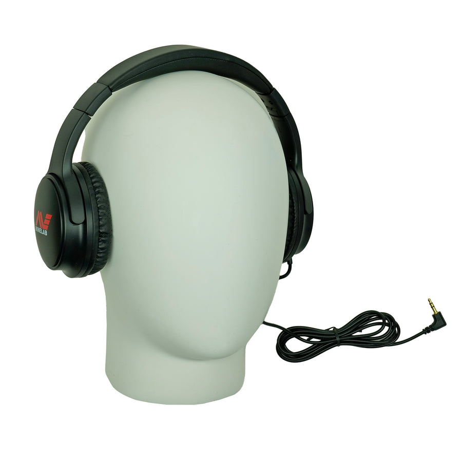 Black over-ear wired headphones displayed on a white mannequin head, with a coiled cable and a red-and-white Minelab logo visible on the earcup.