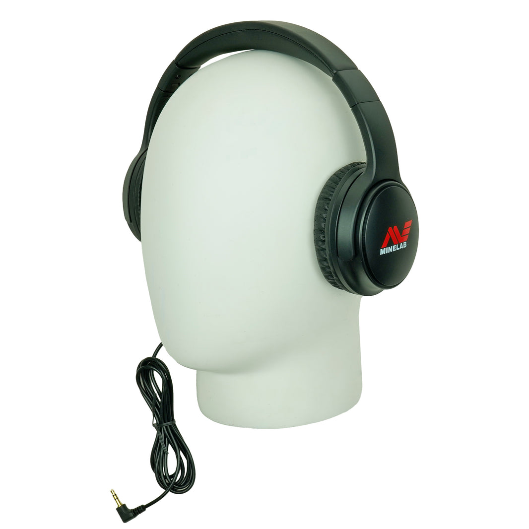 Black over-ear wired headphones displayed on a white mannequin head, with a coiled cable and a red-and-white Minelab logo visible on the earcup.