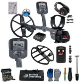 A metal detector kit laid out on a white background, including a gray and black Minelab metal detector with coil, two control units, headphones, battery charger, module, gloves, shovel, digging knife, bag, and accessories. The Minelab brand is visible on multiple items.