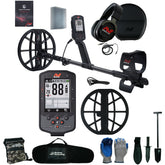 A metal detector kit laid out on a white background, including a black metal detector with a large coil and control box, over-ear headphones, carrying case, ground coil, gloves, shovel, brush remover, and accessories. The detector and accessories show the visible brand name 'Serious Detecting'.