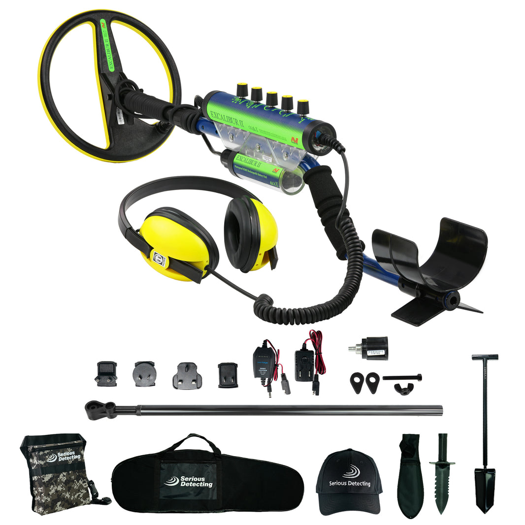 A metal detector kit with a black and yellow coil, blue and green control unit, yellow headphones, a black carrying case, accessories a camouflage bag, all arranged on a white background. The brand 'Serious Detecting' is visible on the cap, bag, and headphones.