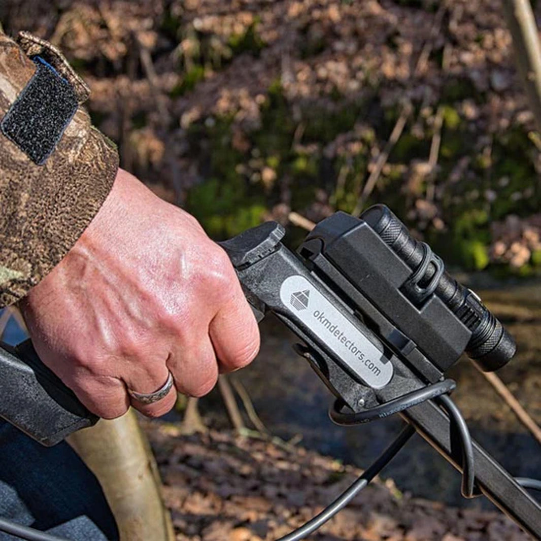 Detectorist holding the OKM Pulse Nova control unit in the field