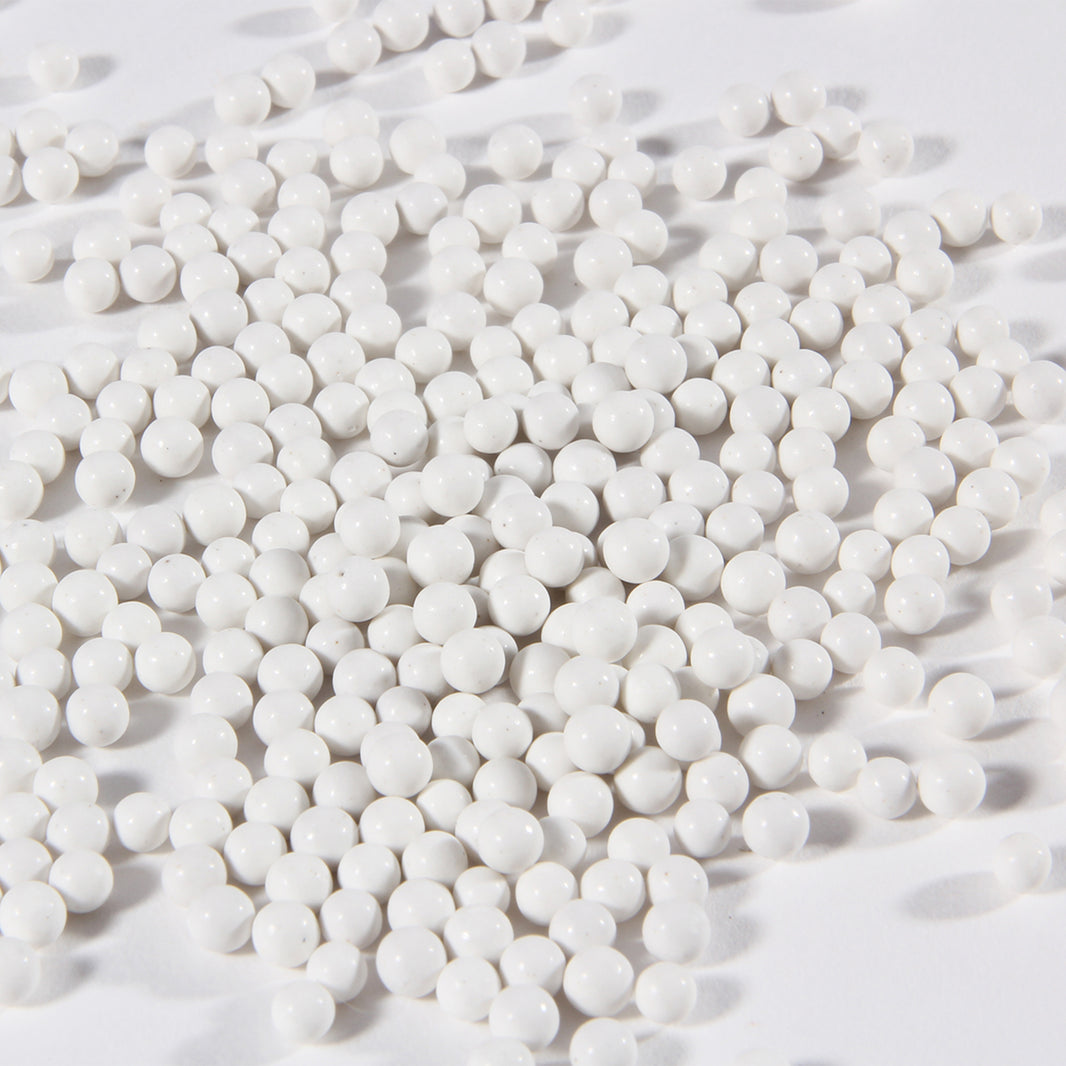 Close-up of white porcelain balls ceramic tumbler media for jewelry polishing