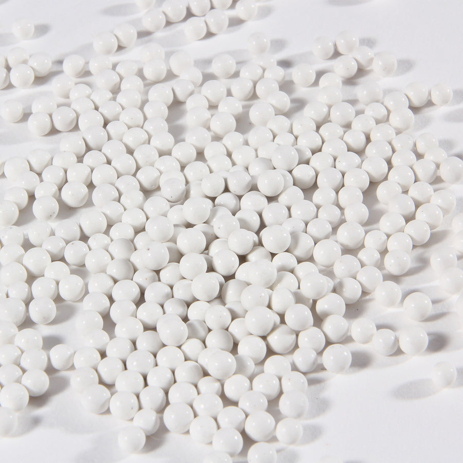 Close-up of white porcelain balls ceramic tumbler media for jewelry polishing