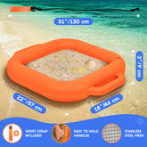 An inflatable orange beach sand pit with a wrist strap, shown on a sandy beach with ocean water in the background. White dotted lines and blue measurement labels indicate dimensions: 51 inches (130 cm) in length, 22 inches (57 cm) in width, and 18 inches (46 cm) in depth.