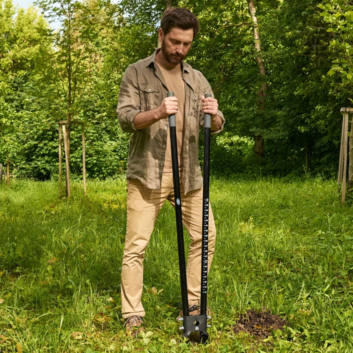 Man using the CKG Heavy Duty Post Hole Digger.  Inserted into the ground.