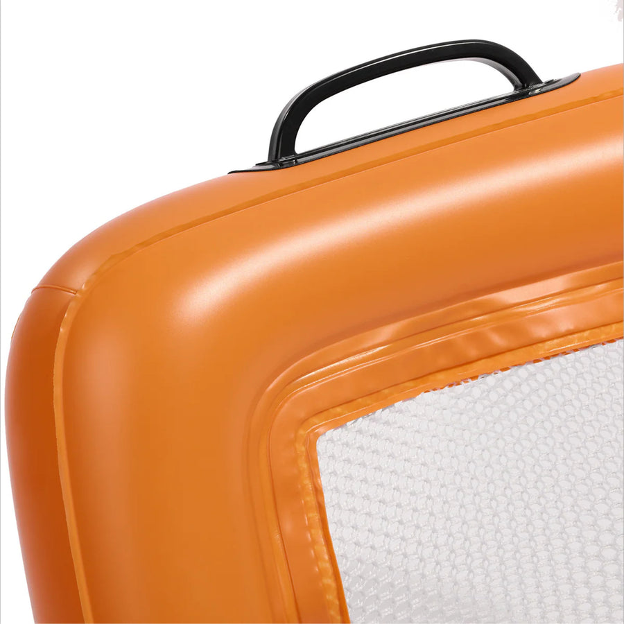 Close-up of an orange floating beach sifter upright with a black handle on a white background