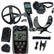 A black metal detector kit with a large coil, handheld controller, headphones, belt clip, battery, carrying case, and accessories, arranged on a white background. The main device shows the brand name 'DEUS'.