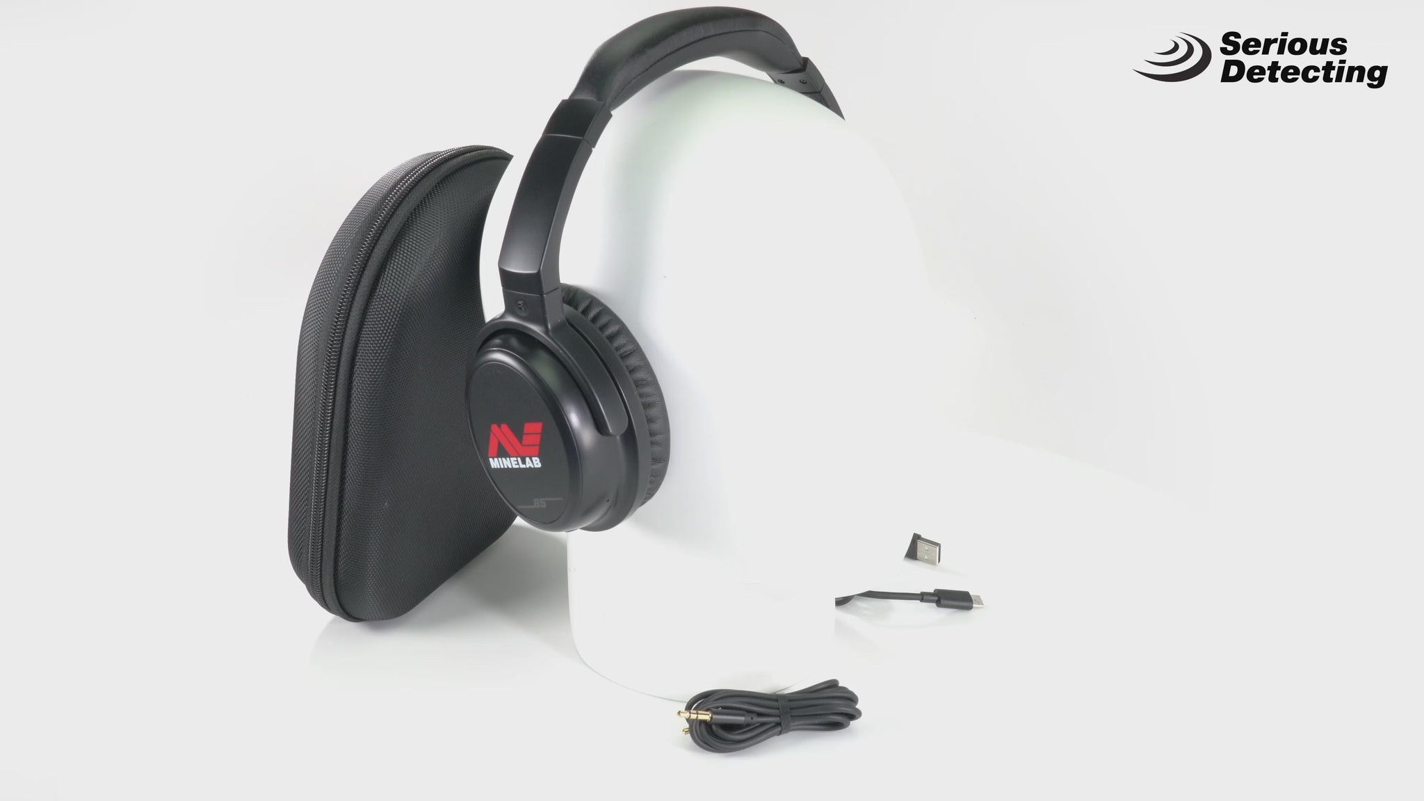 video of the Minelab ML 85 Bluetooth Wireless Low Latency Headphones in black color with the Minelab logo visible on the ear cup on a mannequin head with the case and accessories