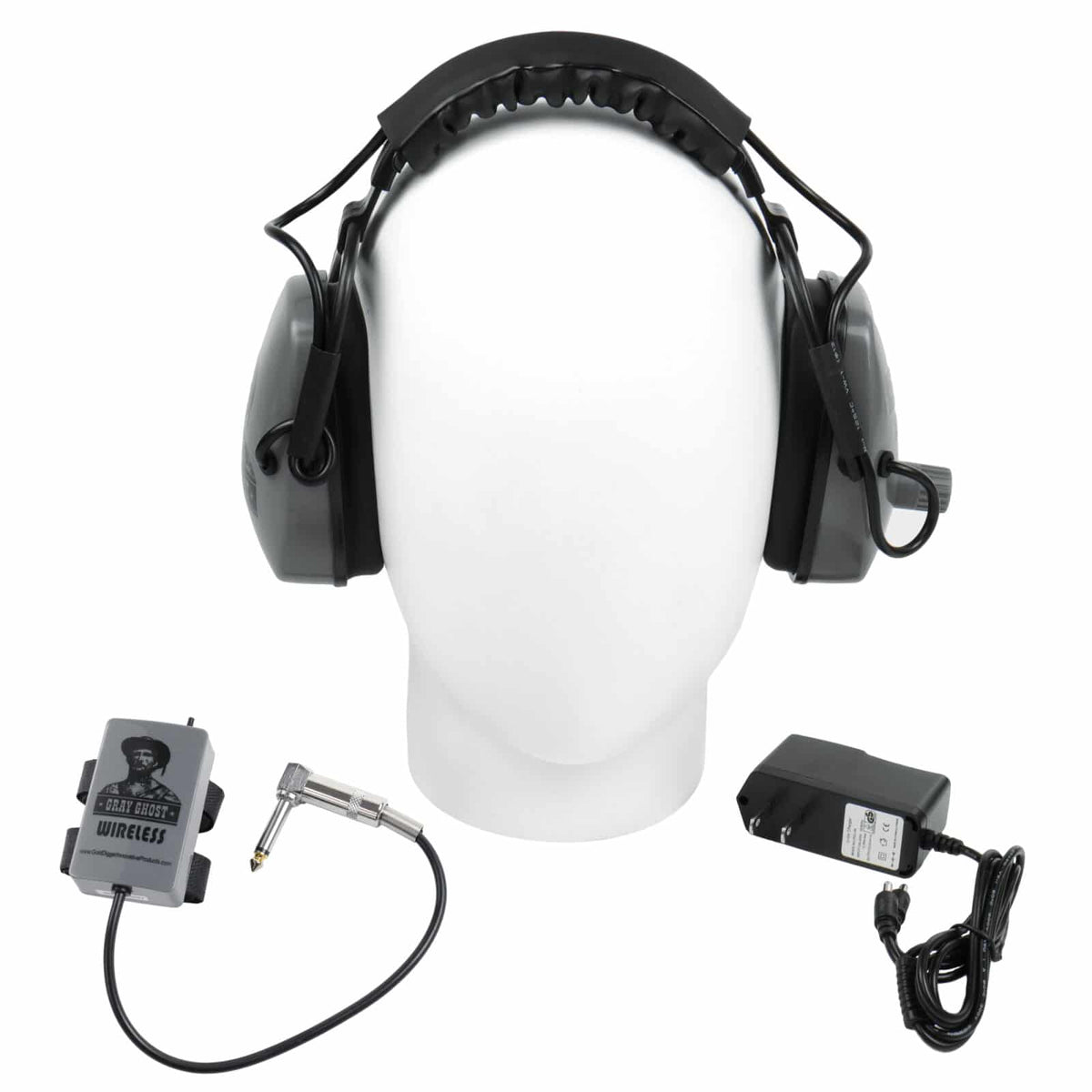 Front view of Gray Ghost Wireless Platinum headphones on a display head with transmitter and dual charger