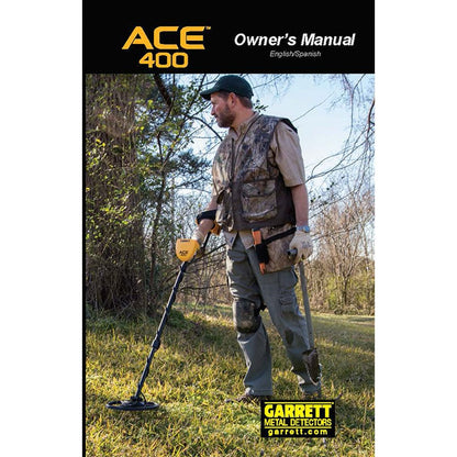 The cover of the English/Spanish version of the Garrett ACE 400 digital owner's manual, depicting a male detectorist in a grassy field holding the ACE 400 and a shovel. 